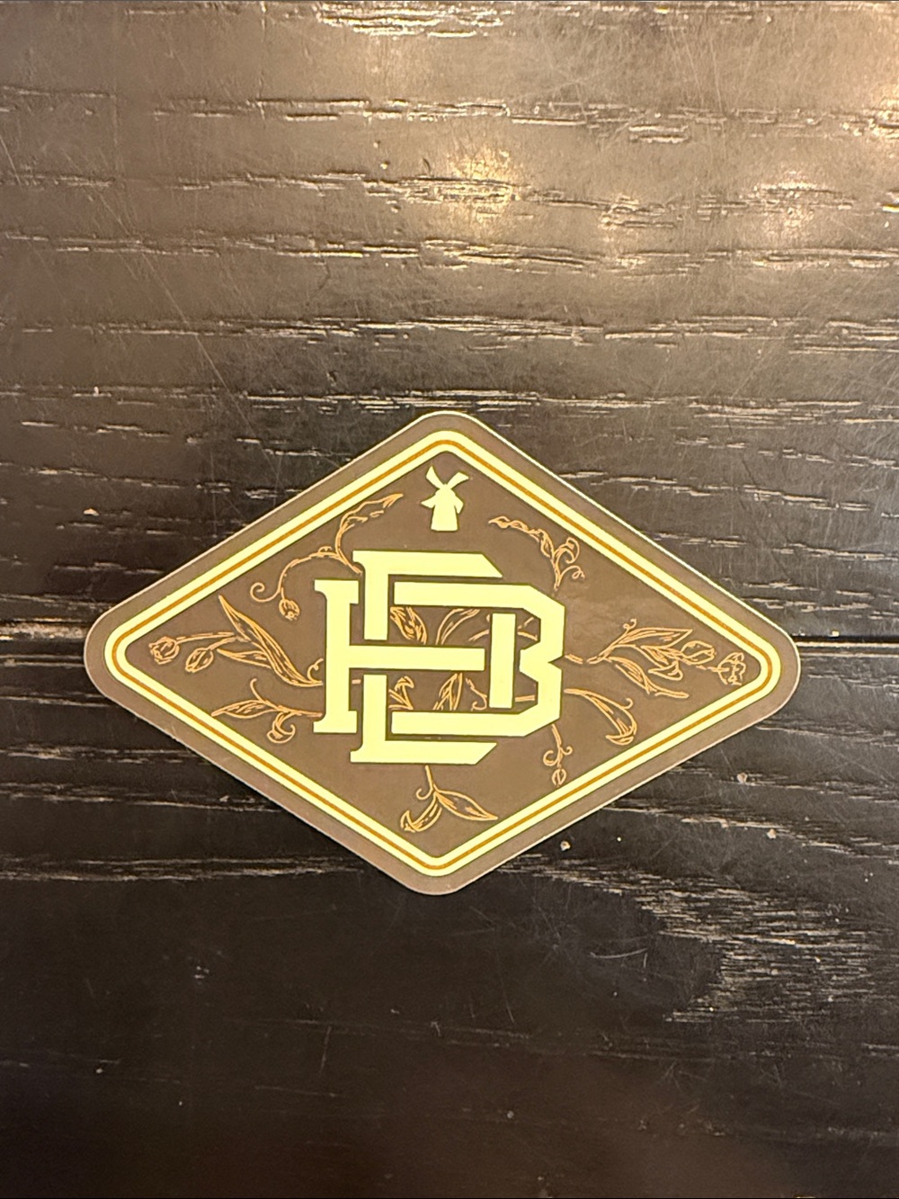 Dutch Bros Decorative Brown and Gold Floral Diamond Emblem Sticker